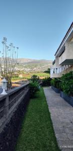 einen Gang neben einem Gebäude mit grünem Gras in der Unterkunft Elegant and Peaceful Aparments with Pool and Garden in Puerto de la Cruz