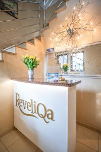a white counter with a regalo sign on it in a room with stairs at ReveliQa in Pobierowo