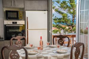 cocina con mesa con sillas y nevera blanca en Villa Stunning Views en Karavadhos