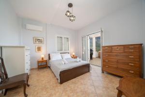 1 dormitorio con 1 cama, vestidor y escritorio en Villa Stunning Views en Karavadhos