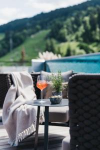 a glass of wine sitting on a table on a patio at JOHANN Schladming in Schladming
