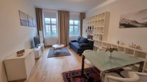 un soggiorno con divano blu e tavolo di Sunny Apartment next to Metro 1BR a Vienna