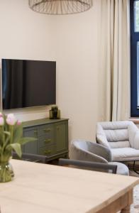 ein Wohnzimmer mit 2 Stühlen und einem TV in der Unterkunft Vaksali Apartment! in Viljandi