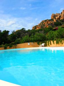 una piscina azul con una silla blanca en una playa en Villa Niko en Costa Paradiso