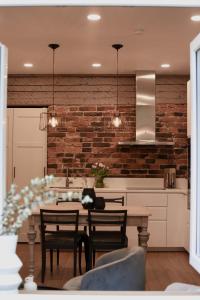 a kitchen with a table and a brick wall at Vaksali Apartment! in Viljandi