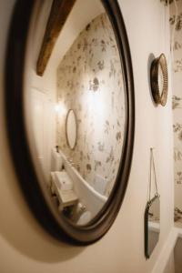 espejo colgado en la pared del baño en Historical Penthouse on Isola dei Pescatori, en Someraro