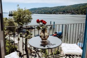 eine Vase mit Rosen auf einem Tisch auf einem Balkon in der Unterkunft Historical Penthouse on Isola dei Pescatori in Someraro