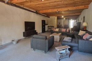 uma sala de estar com sofás e uma televisão de ecrã plano em Chambre dans maison de ville - 2 Personnes em Oloron-Sainte-Marie