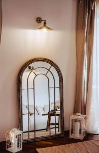 - un miroir dans l'angle d'une chambre avec un lit dans l'établissement Historical Penthouse on Isola dei Pescatori, à Someraro