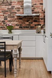 a kitchen with white cabinets and a brick wall at Vaksali Apartment! in Viljandi