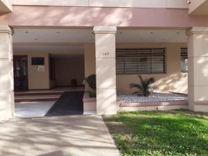 un grand bâtiment avec un palmier dans la cour dans l'établissement Departamento temporal Mariano, à Santa Rosa