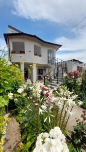 a house with a bunch of flowers in front of it at 3M Vila in 2 Mai