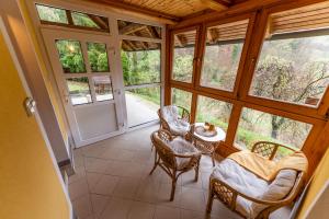 a screened in porch with a table and chairs at Vila DOLINA MIRU in Zavrč