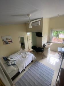 a bedroom with a bed and a desk and a ceiling fan at Descanso do Jordão in Abraão