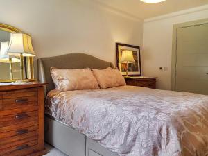 a bedroom with a bed and two lamps and a dresser at Torrance At Abbey Park Avenue in St. Andrews