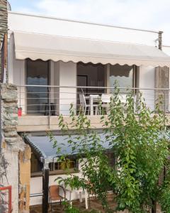 新马尔马拉斯Elpida Maisonette的白色的房子,设有带桌椅的阳台