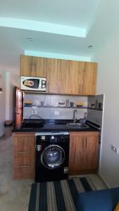 a kitchen with a sink and a washing machine at Two Bedrooms for Families only Chalet Sia Lagoon Golf Porto Marina للعائلات فقط شاليه غرفتين كريستال لاجون جولف بورتو مارينا in El Alamein