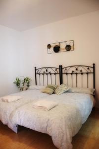 a bedroom with a large bed with a metal headboard at Retiro del Bullaque in El Robledo