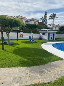 une cour avec deux chaises et une piscine dans l'établissement Acogedor apartamento en la playa vera, à Vera