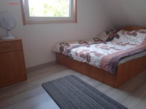 a bedroom with a bed and a window and a rug at Domki letniskowe Aneta in Trzęsacz