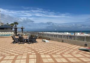 a patio with a table and chairs next to the beach at Shoalwater 704 in Orange Beach