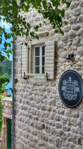 a window and a sign on a stone building at Casa Vita Nova in Perast