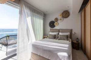 a bedroom with a bed and a view of the ocean at Nōema Premium Stay in Neos Marmaras