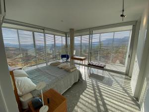 1 dormitorio con cama y ventana grande en Pluto luxury Villa, en Ora