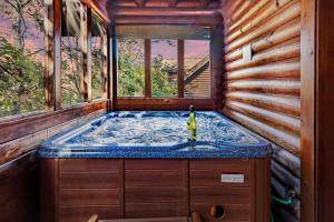 a jacuzzi tub in a log cabin at 2 Miles from Dollywood Family Resort with Seasonal Outdoor Swimming Pool, Year around Heated Indoor Swimming Pool, Townhome Style Cabin, Private Hot Tub, Arcade, TV, Wifi, Kitchen with Refrigerator, Washer and Dryer in Pigeon Forge