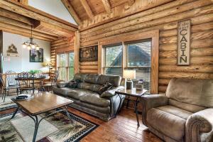 a living room with a leather couch and a table at 2 Miles from Dollywood Family Resort with Seasonal Outdoor Swimming Pool, Year around Heated Indoor Swimming Pool, Townhome Style Cabin, Private Hot Tub, Arcade, TV, Wifi, Kitchen with Refrigerator, Washer and Dryer in Pigeon Forge