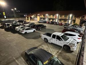 een groep auto's geparkeerd op een parkeerplaats 's nachts bij Budget Inn-Gadsden in Gadsden