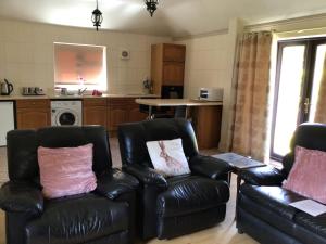 a living room with two leather chairs and a kitchen at Mary's in Selby