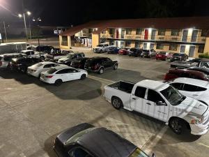 een groep auto's geparkeerd op een parkeerplaats bij Budget Inn-Gadsden in Gadsden