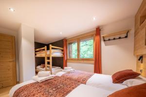 two beds in a bedroom with a bunk bed at Appartements Chalet Le Fornay in Morzine