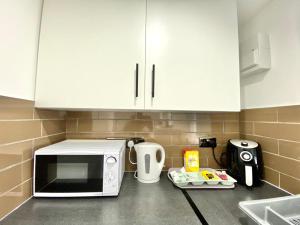 a kitchen with white cabinets and a microwave on a counter at Kyle house in Longley