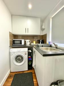uma cozinha com uma máquina de lavar roupa e um lavatório em Kyle house em Longley