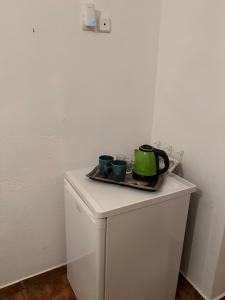 a white cabinet with two cups on top of it at Georgakas rooms in Sfinárion