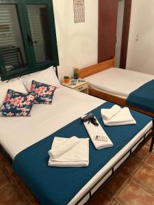 a hotel room with two beds with towels on them at Georgakas rooms in Sfinárion