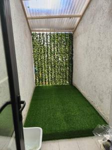 een kleine kamer met een groene vloer en een raam bij C&C Apartment at Kileleshwa in Nairobi