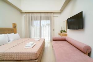 a bedroom with a pink bed and a flat screen tv at Yasemi Luxury Rooms in Limenas