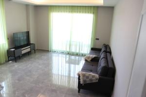 een woonkamer met een bank en een televisie bij Appartement 1+1 in Alanya in Alanya