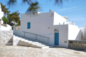 een wit gebouw met een blauwe deur en een trap bij Thavma in Sifnos in Apollonia