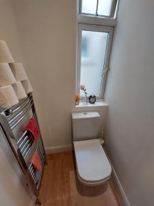 a small bathroom with a toilet and a window at Nice and comfortable Shared Flat in Surbiton in Malden