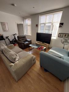 uma sala de estar com um sofá e uma televisão em Nice and comfortable Shared Flat in Surbiton em Malden