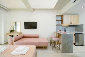 sala de estar con sofá rosa y cocina en Yasemi Luxury Rooms, en Limenas