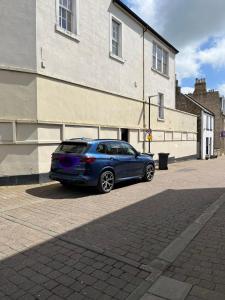 a blue car parked in front of a building at 7A Murray Street in Duns