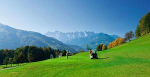 un grupo de personas jugando al golf en un exuberante campo verde en Alpen-Chalet-Sol-Alpium, en Reit im Winkl