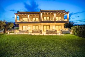 萨索斯Yasemi Luxury Rooms的一栋前面有草坪的大房子