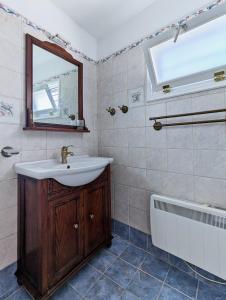 een badkamer met een wastafel, een spiegel en een bad bij Thavma in Sifnos in Apollonia