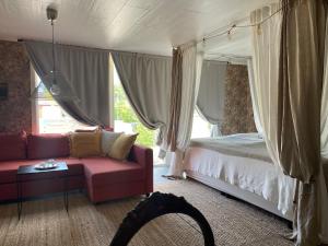- une chambre avec un lit, un canapé et une fenêtre dans l'établissement Pia’s Country House, à Båstad